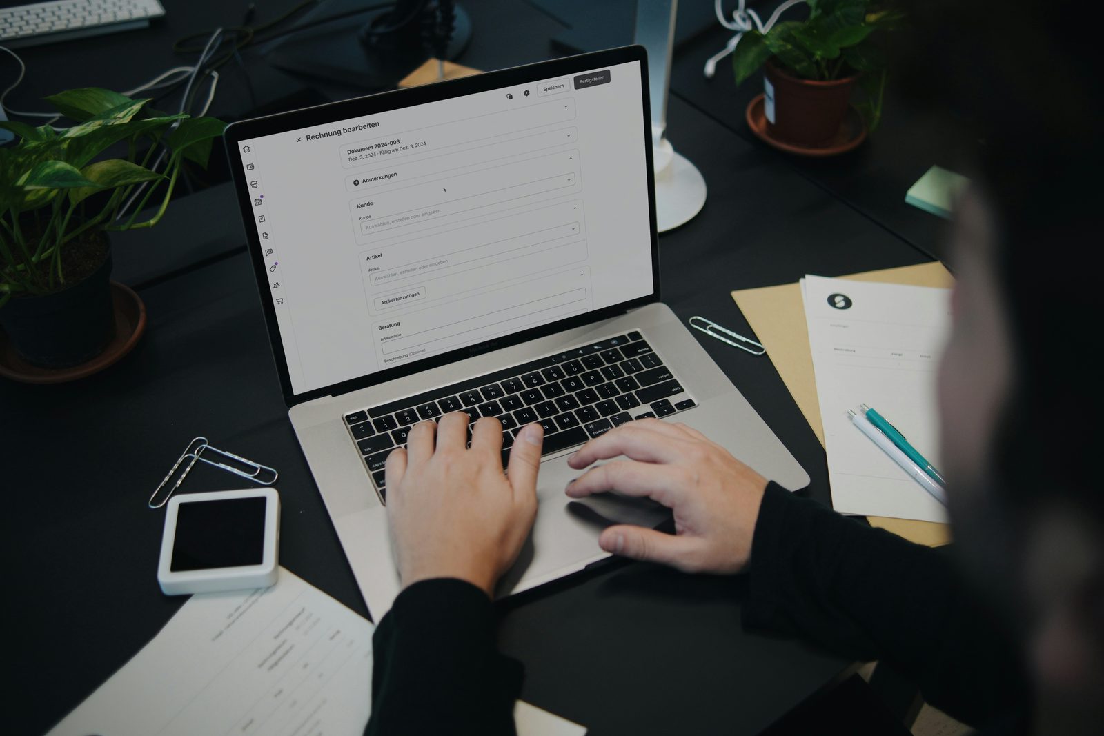 Personne travaillant sur un ordinateur portable avec des documents de facturation